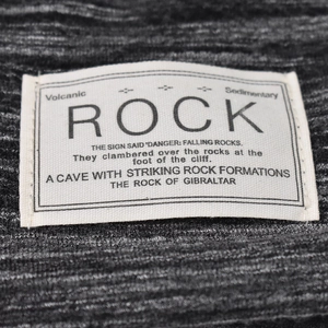Versatile dark grey knitted slouchy beanie hat featuring a white Rock slogan woven patch