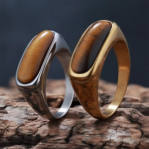 Detail of vintage silver and gold tiger eye stone rings on natural wood bark stand
