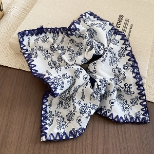 Close-up of knotted floral headband with blue print and contrast stitching detail