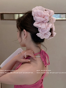 Side view of pink layered organza bow hair claw clip worn by a model in soft lighting
