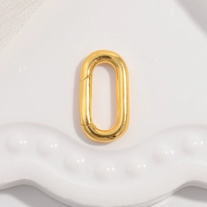 Close-up of golden oval spring clasp connector for jewelry making on a white tray