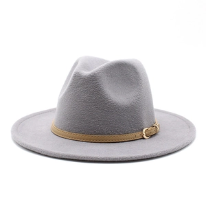Detail of grey woolen fedora hat featuring a light brown leather band and gold metal buckle
