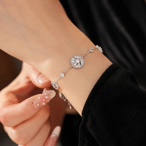 Detailed close-up of 18K gold plated bracelet with zircon starburst charms on wrist