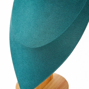 Detailed macro view of teal velvet neck display with a premium solid wood base