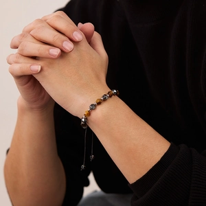 Detail of tiger eye and hematite beads on an adjustable braided cord bracelet