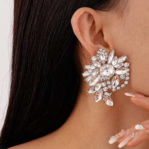 Detail view of large geometric flower earrings with sparkling rhinestones on a female model