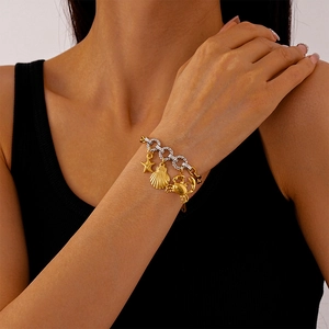 Detail of ocean-themed charm bracelet with starfish and shell pendants on wrist