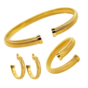 Détail macro d'un ensemble collier, bracelet et boucles d'oreilles plaqué or 18 carats