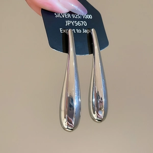 Detail of 925 sterling silver teardrop earrings featuring a high-polished mirror finish