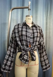 Detail eines klassisch schwarz-weiß karierten Flanellhemds mit Knöpfen und Knotensaum
