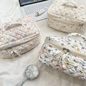 Detailed view of quilted cotton cosmetic bags featuring cute bear and bow patterns