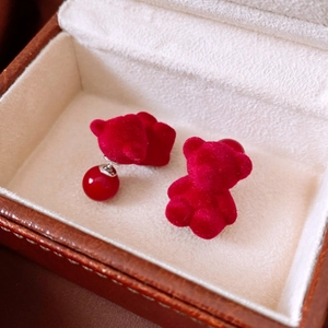 Detail shot of red flocked bear earrings with velvet texture and matching glossy beads