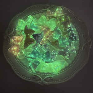 Luminous bow-knot beads in assorted colors glowing on a decorative white tray