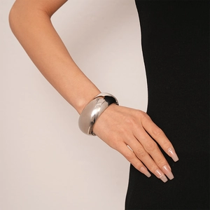 Close-up of polished silver wide metal cuff bracelet with reflective mirror finish