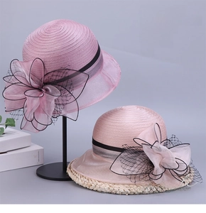 Detail of pink and purple organza sun hats with mesh flower bows and woven texture