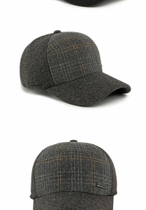 Dettaglio del cappello grigio con patchwork a quadri fini ed emblema MOWRID in metallo