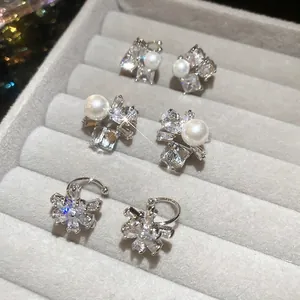Three-piece set of zircon flower and pearl earrings displayed in a velvet jewelry box