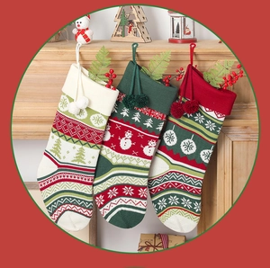 Close-up of three knitted Christmas stockings with snowflake and tree patterns