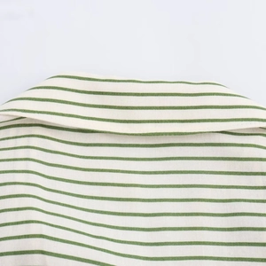 Détail d'une chemise à col rayée vert et blanc montrant la texture du tissu de coton