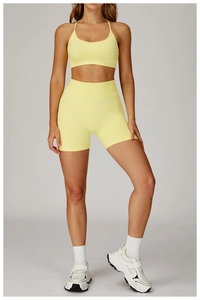 Detail view of seamless high-stretch sports bra and shorts set in soft pale yellow color