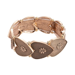 Vintage gold heart and flower elastic bracelet with retro engraved pattern on white background