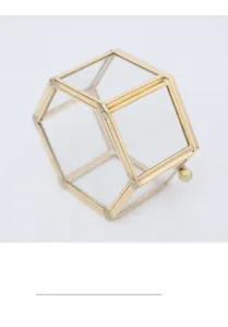 Detail of a geometric brass metal frame glass jewelry box with a spherical handle