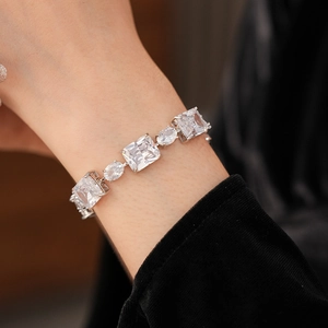 Detail of luxury silver bracelet with large emerald and oval cut cubic zirconia stones