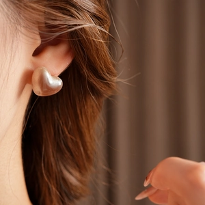 Vue rapprochée de boucles d'oreilles cœur en résine champagne doré sur le mannequin