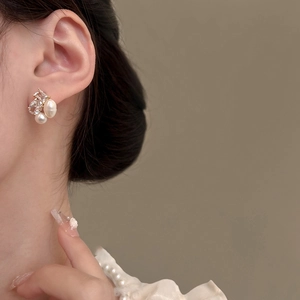 Elegant geometric earrings with freshwater pearls and zircons on a model side profile