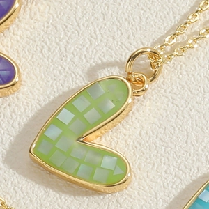 Macro shot of colorful shell mosaic heart pendant with gold plated chain necklace