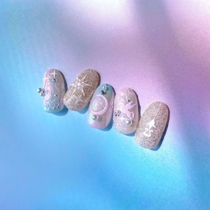 Macro detail of 5D embossed nail stickers featuring unicorn, pearls and stars on blue base