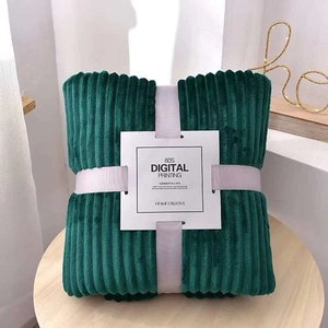 Close-up of a dark green striped flannel blanket folded with a premium gift tag