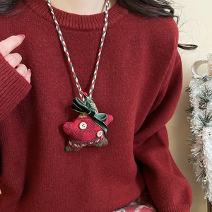 Detail of Christmas plush star necklace with red green plaid and velvet bow accent