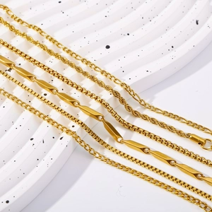 Detail of five assorted 18K gold plated stainless steel chain bracelets on a wavy background