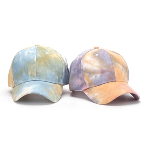 Dettaglio di cappellini da baseball tie-dye con motivi artistici e visiera curva sportiva