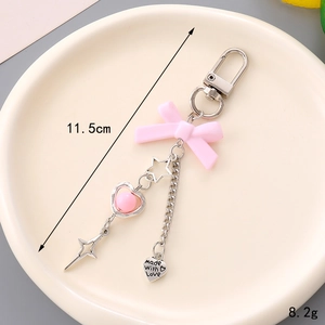 Porte-clés nœud rose avec breloques étoile et cœur sur plateau céramique, longueur 11,5 cm