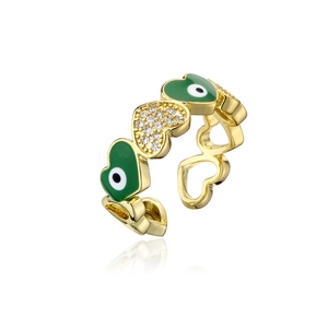 Macro shot of gold heart ring with green enamel devil eyes and sparkling white zircons
