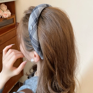 Close-up of grey and black plaid headband on model featuring a decorative Korea label