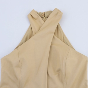 Detail view of beige halter neckline with cross wrap design and button closure