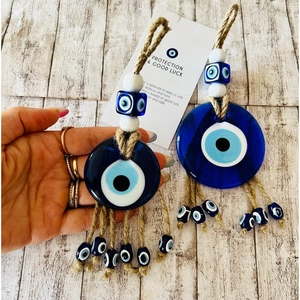 Close-up of Turkish Evil Eye glass pendant with blue eye beads and natural jute rope