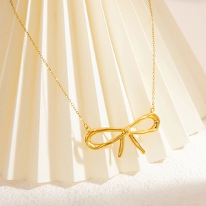 Titanium steel necklace with 18k gold butterfly pendant on a decorative fan background
