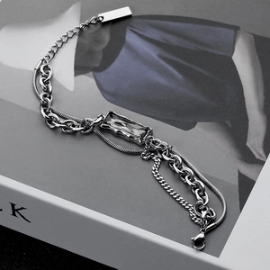 Industrial layered silver chain bracelet featuring a dark grey gemstone on a book