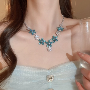 Heavy zircon flower necklace with deep blue crystal clusters and silver finish