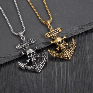 Detailed close-up of anchor and skull pendants in gold and silver stainless steel