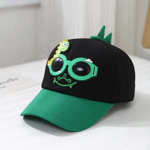 Détail de la casquette dinosaure pour enfant avec lunettes vertes et tissu en coton