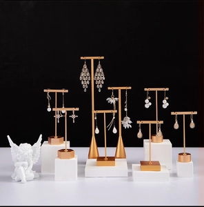 Detailed view of matte gold T-bar earring stands with marble bases for jewelry display