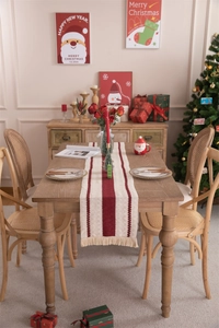 Detail of red and beige striped woven table runner with decorative tassels for Christmas