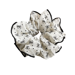 Minimalist white polka dot and bow pattern scrunchie with black hemmed edges