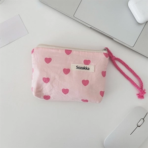 Pink heart-patterned canvas pouch with zipper, brand tag, and matching wrist strap detail