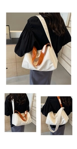 Detail view of large capacity cream tote bag with stylish orange shoulder strap
